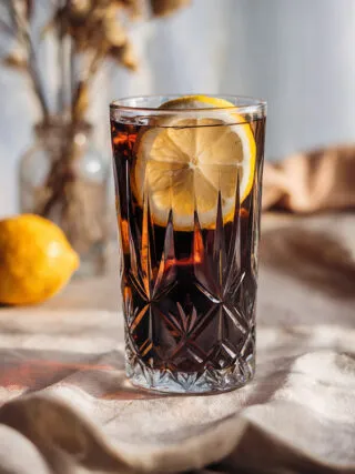 Wodka Cola in einem Glas mit Eis und Zitronenscheibe, bereit zum Genuss auf einer deutschen Party.