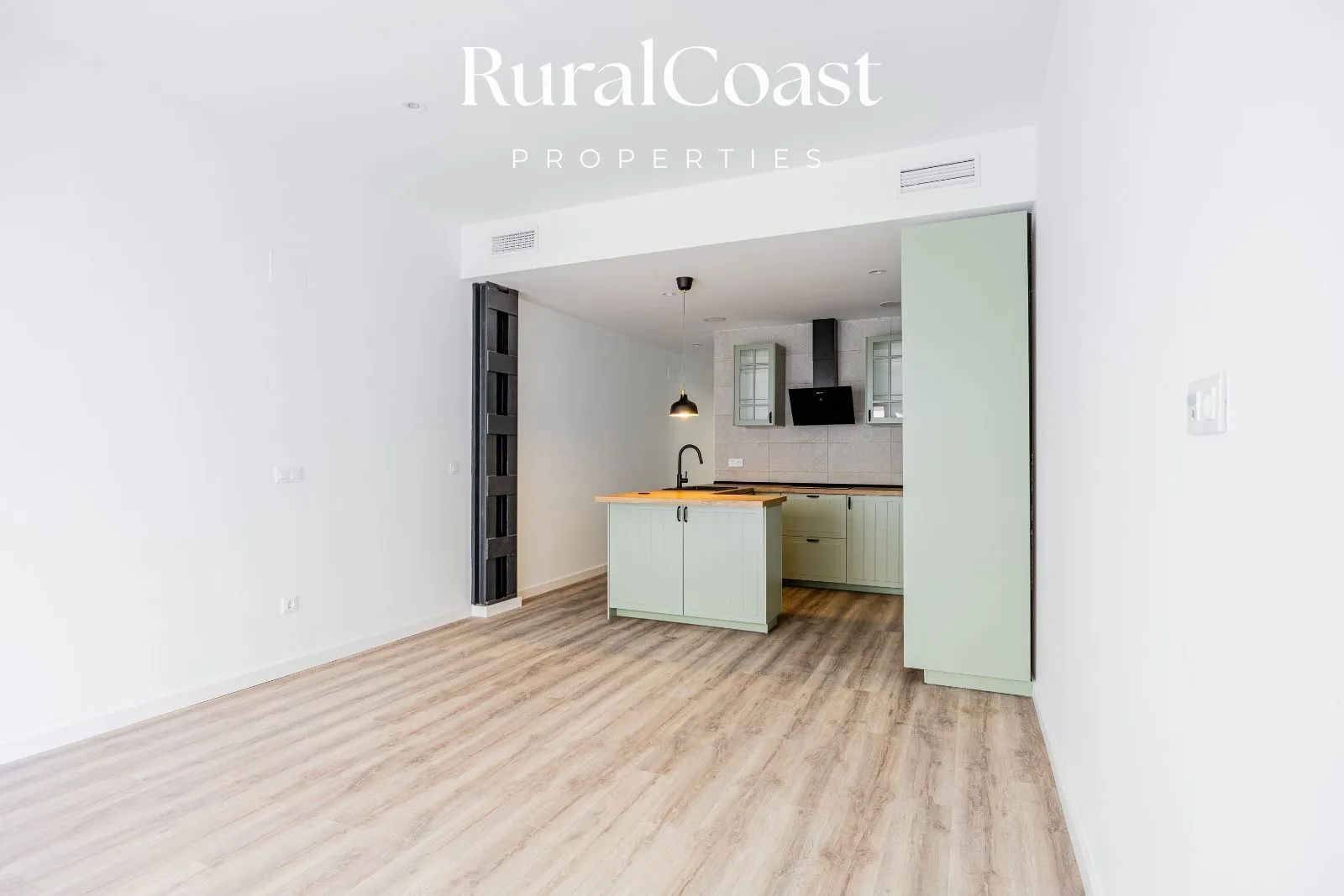 Wohnbereich mit offener Verbindung zur amerikanischen Küche, minimalistisch und hell gestaltet