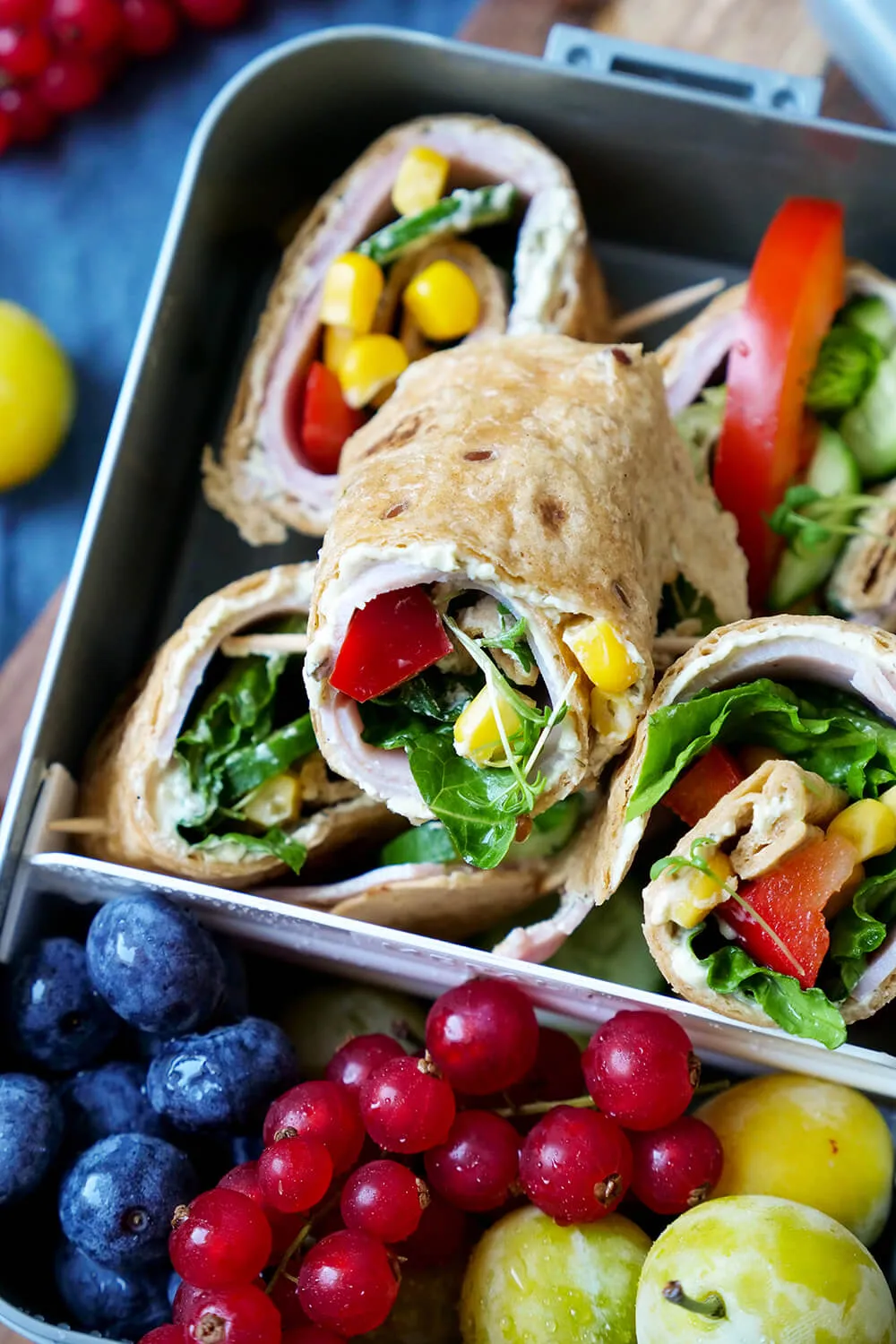 Wraps für Kinder mit Schinken, Mais und Salat, zusammen mit Obst in einer Brotdose