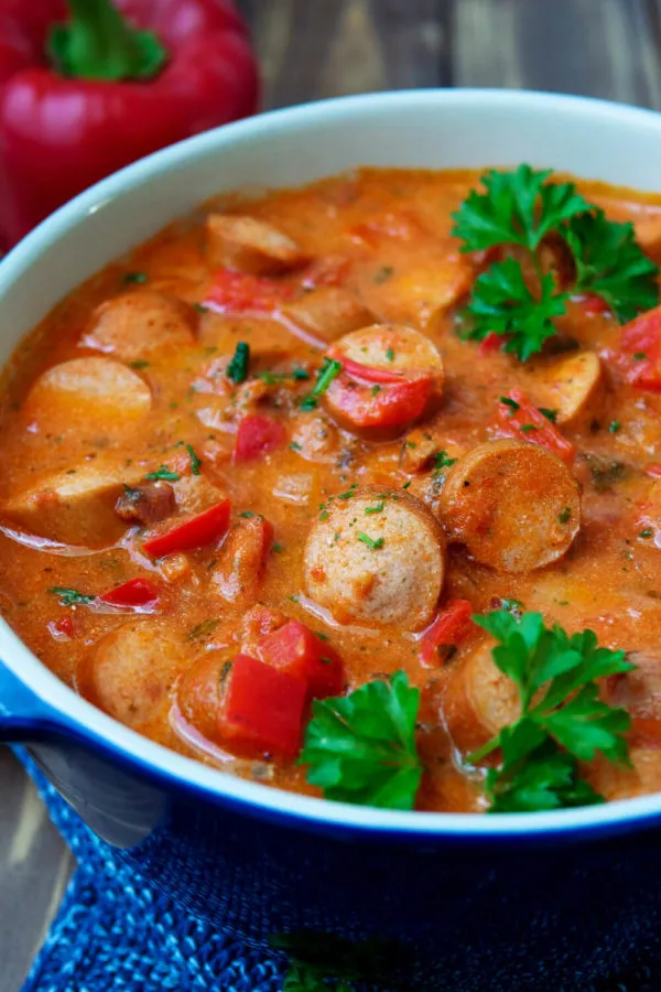 Würstchengulasch mit Paprika, Wiener Würstchen und frischer Petersilie in einer stilvollen Schüssel angerichtet