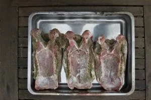 Würzen der Gänsebrust mit Majoran und Salz auf der Knochenseite