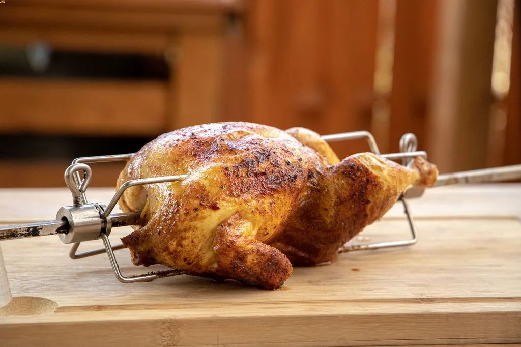 Würzen des Hähnchens für den Drehspieß mit einer Marinade