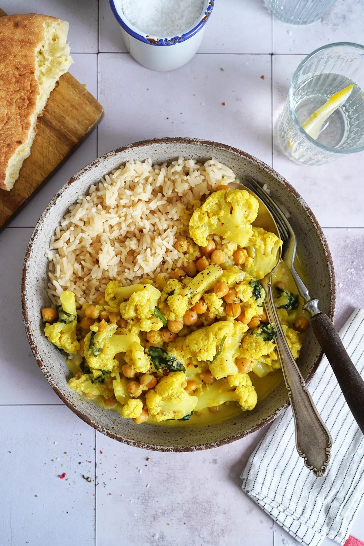 Würziges Kichererbsen Curry mit Blumenkohl und frischen Kräutern in einer Servierschale