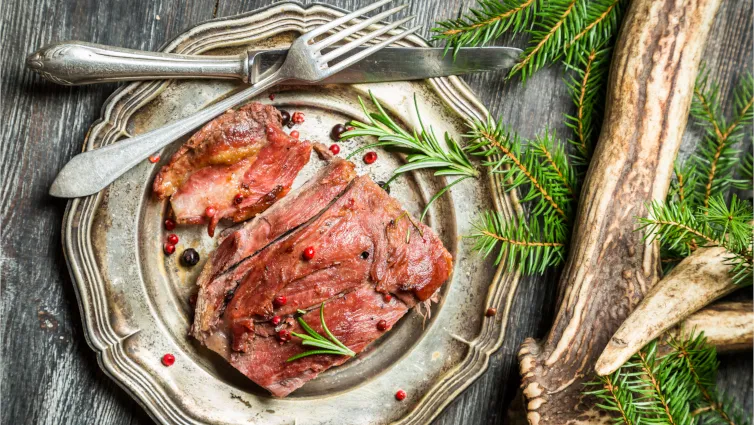 Zart geschmorte Rehkeule mit Rosmarin und Beilagen, bereit zum Servieren – ein klassisches deutsches Rehkeule Rezept.