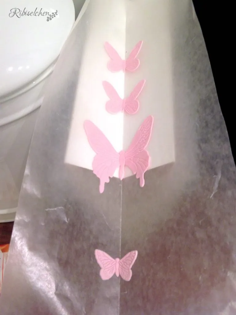 Zarte, ausgeschnittene Schmetterlinge aus Blütenpaste vor dem Trocknen, bereit für die Tortendekoration