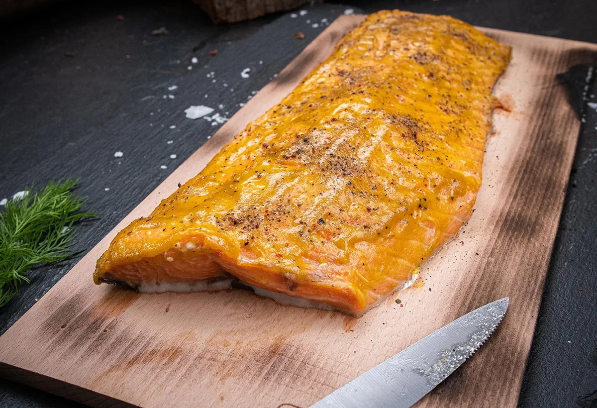Zarter Lachs auf einem Zedernholzbrett, verfeinert mit Honig-Senf-Marinade, ein beliebtes der Fisch Grillrezepte mit Raucharoma