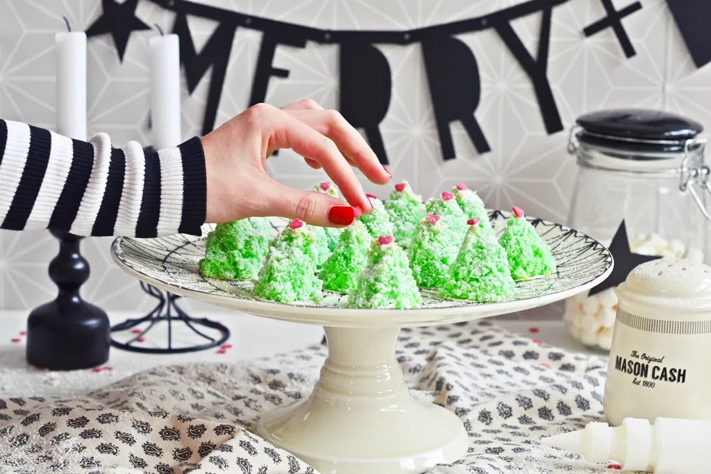 Zartgrüne Kokosmakronen in Tannenbaumform auf einem Teller, perfekt für festliche Weihnachtsbäckerei
