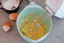 Zimmerwarme Eier und Gewürze werden zur cremig gerührten Butter hinzugefügt