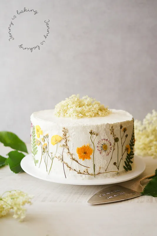 Zitronen-Holunder-Torte mit frischen Blüten und Zitronenscheiben.