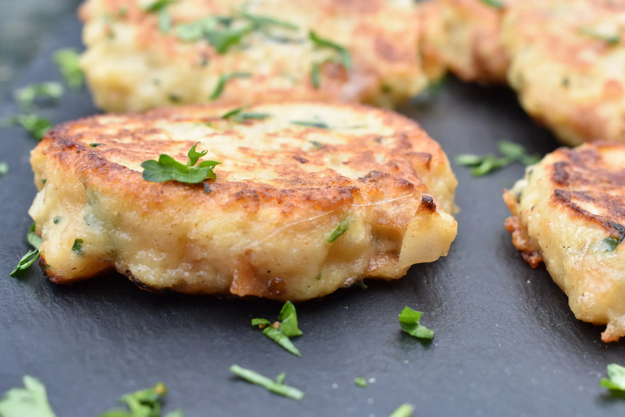 Zubereitete Kaspressknödel in einer gusseisernen Pfanne, perfekt gebraten.