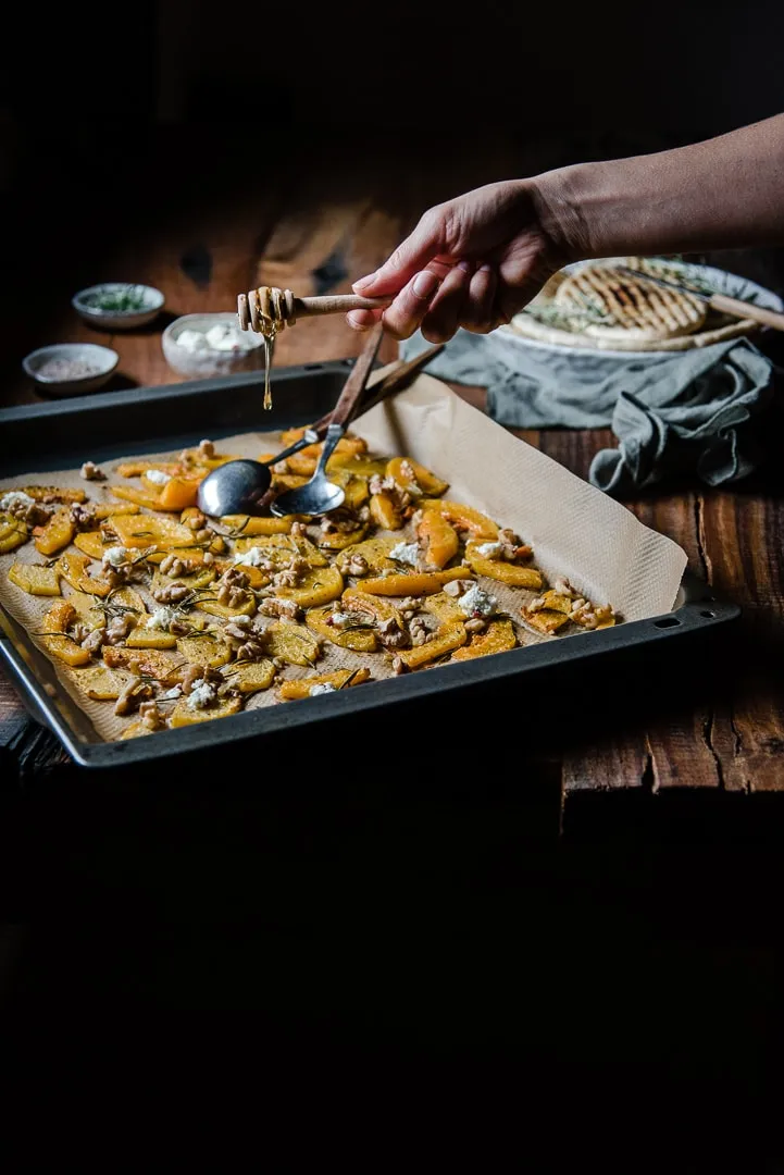 Zubereiteter Butternut-Kürbis mit Walnüssen und Feta auf Backpapier