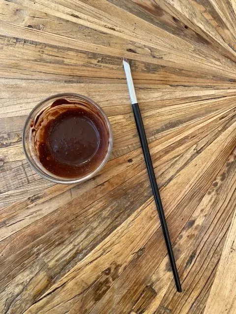 Zubereitungsschritt: Kakaomischung wird auf die Buttercreme gesprenkelt für den Osterkuchen-Effekt