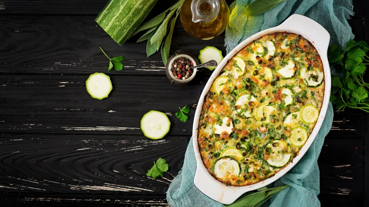 Zucchini-Auflauf in einer Auflaufform, mit Schnittlauch garniert