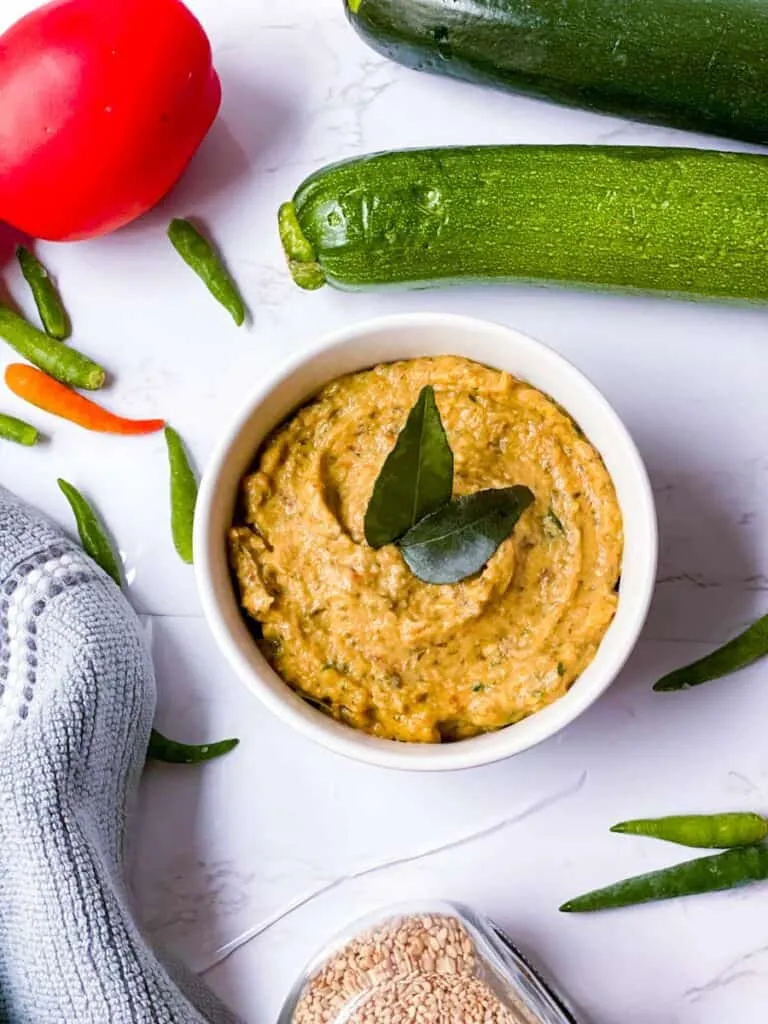 Zucchini Chutney, garniert mit Curryblättern, in einer rustikalen Schale