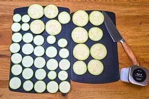 Zucchini und Aubergine in 5 Millimeter dicke Scheiben schneiden und salzen.
