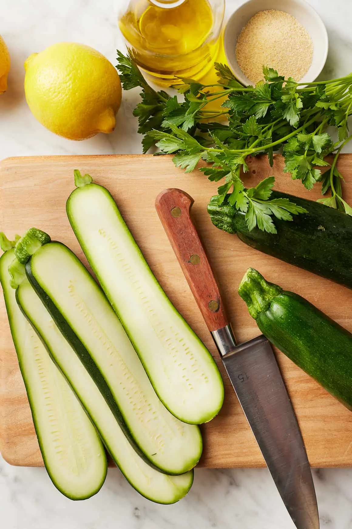 Zucchinischeiben auf Schneidebrett mit Messer