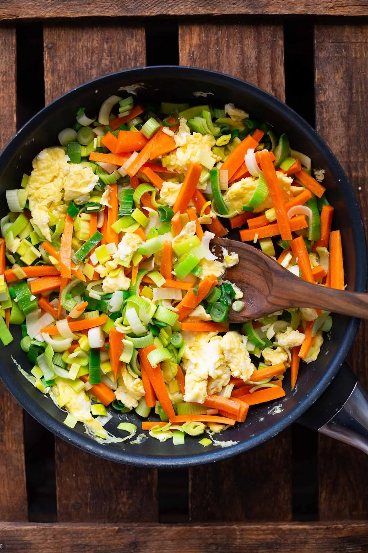 Zuerst werden Ei und Gemüse für die gebratenen Nudeln in einer großen Pfanne kurz angebraten.