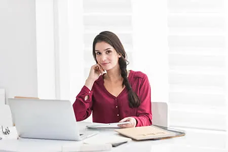 Zufriedene Frau im Büro symbolisiert finanzielle Sicherheit