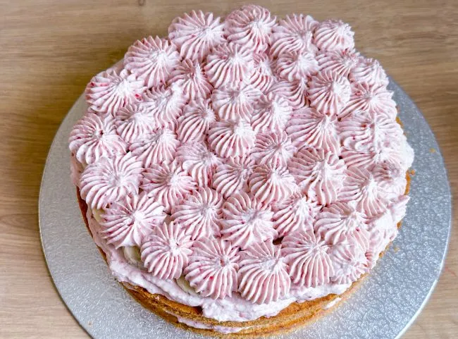 Zusammengesetzte Geburtstagstorte ohne Zucker, verziert mit cremigen Tupfen für den ersten Geburtstag.