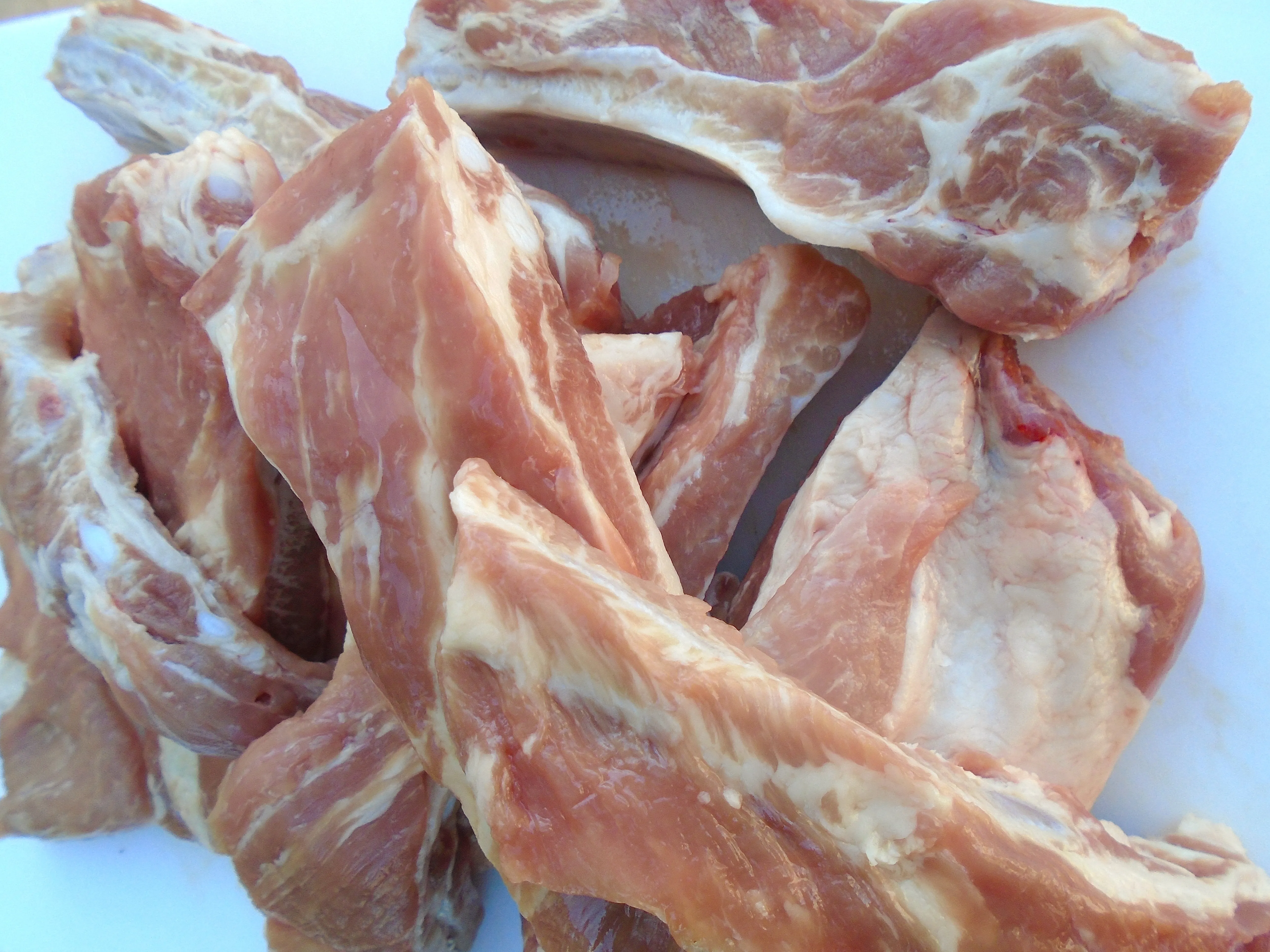 Zuschneiden der Schweinerippchen in einzelne Stücke vor dem Einlegen in Salzlake