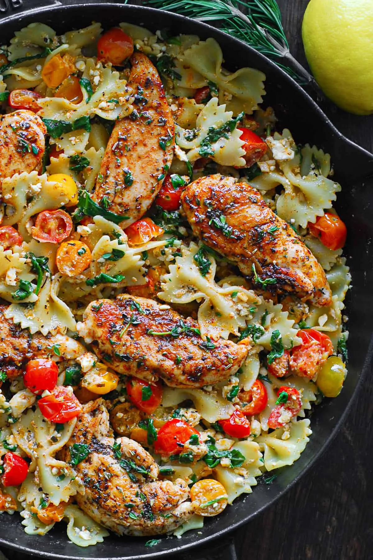 Zutaten für Feta Pasta: Hähnchen, Feta, Tomaten, Spinat und Gewürze bereit zur Zubereitung