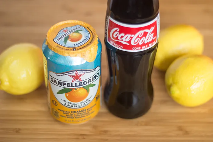 Zutaten für hausgemachte Cola Orange: Sanpellegrino Aranciata, mexikanische Cola und frische Zitronen.