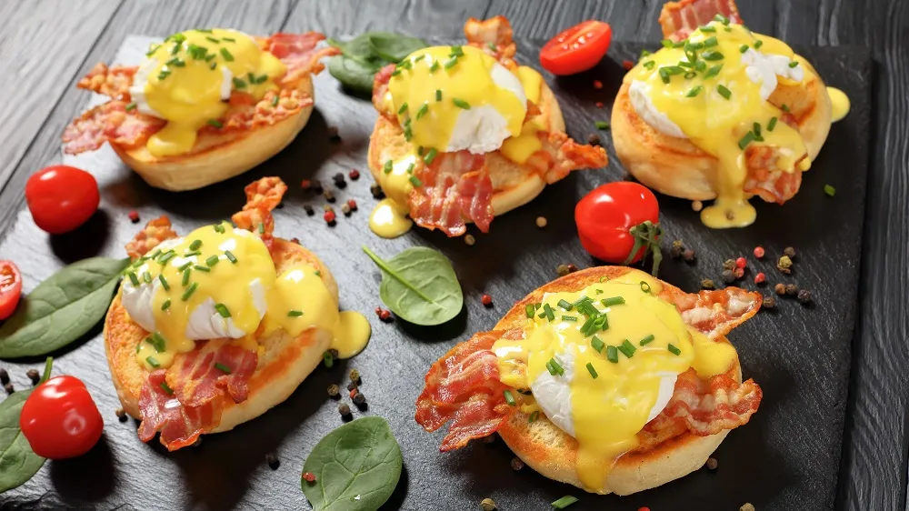 Zwei Eier Benedict mit Sauce Hollandaise und Schnittlauch