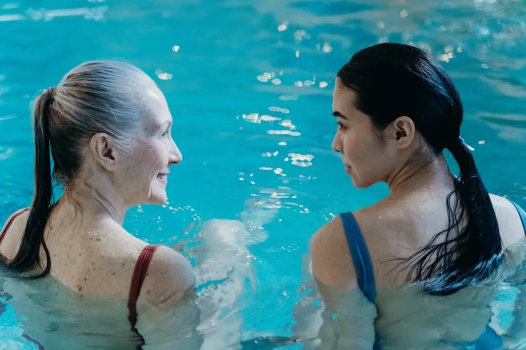 Zwei Freunde lachen beim gemeinsamen Workout im Freien