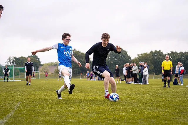 Zwei Fußballspieler auf dem Feld kämpfen um den Ball
