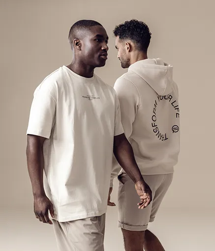 Zwei junge Männer laufen nebeneinander in Streetwear im FITSEVENELEVEN Club