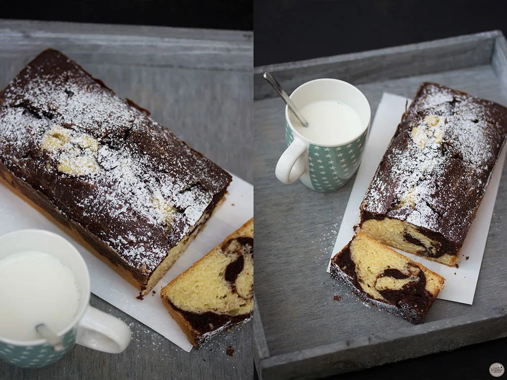 Zwei Scheiben kleiner Marmorkuchen mit Puderzucker bestäubt auf weißem Teller