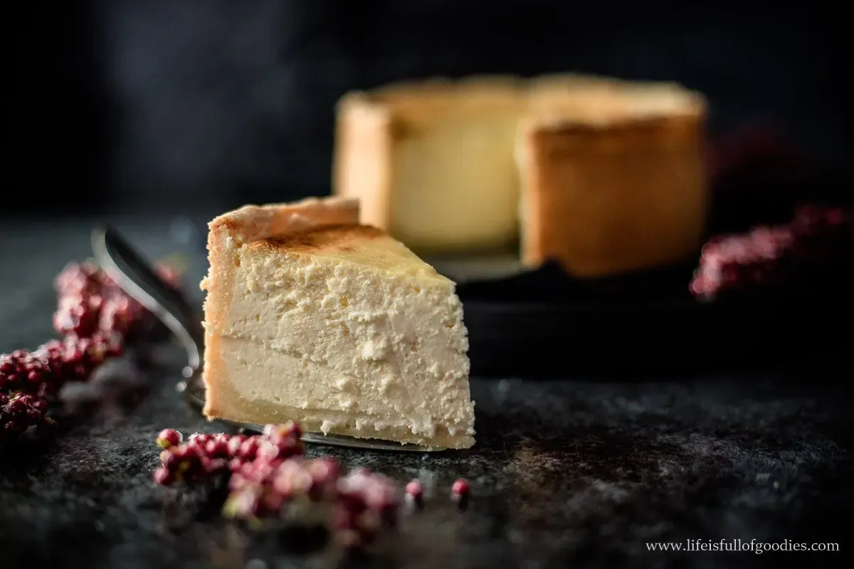 Zwei Stücke cremiger Käsekuchen auf weißen Tellern, bereit zum Servieren