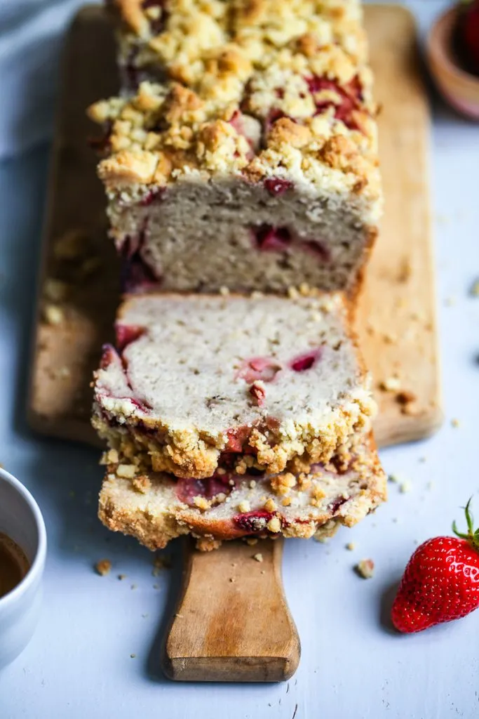 Zwei Stücke Erdbeer-Bananenbrot appetitlich angerichtet, eines davon angeschnitten, um die saftige Füllung mit reifen Bananen und Erdbeeren zu präsentieren. Ideal für ein gemütliches Beisammensein.