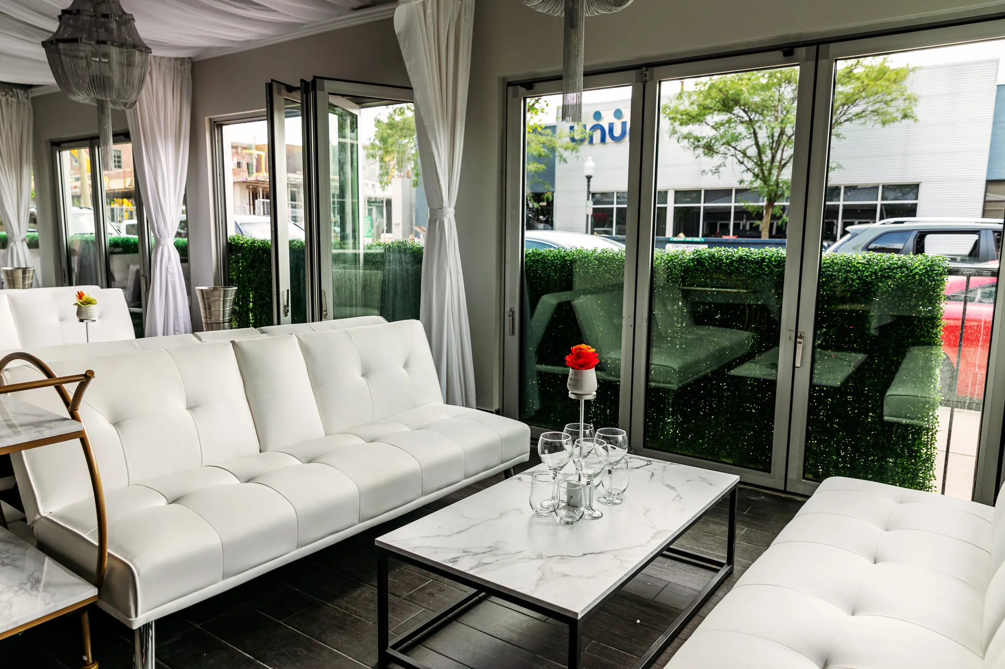 Zwei weiße Sofas stehen sich gegenüber, dazwischen ein Marmortisch. Die Sofas befinden sich in der Nähe des vorderen Fensters.