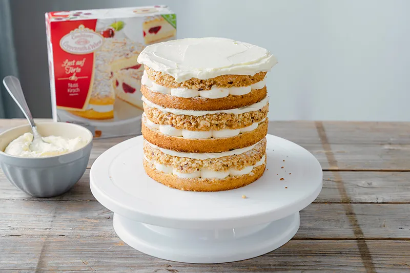 Zweite Tortenschicht auflegen und mit weiterer Sahne bestreichen