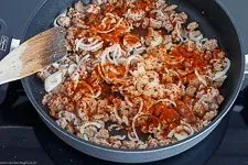 Zwiebeln, Knoblauch und Paprikapulver dünsten mit dem angebratenen Hackfleisch