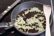 Zwiebeln und Knoblauch werden in Olivenöl in einer Pfanne angedünstet, um die Basis für die Hackfleischfüllung zu legen