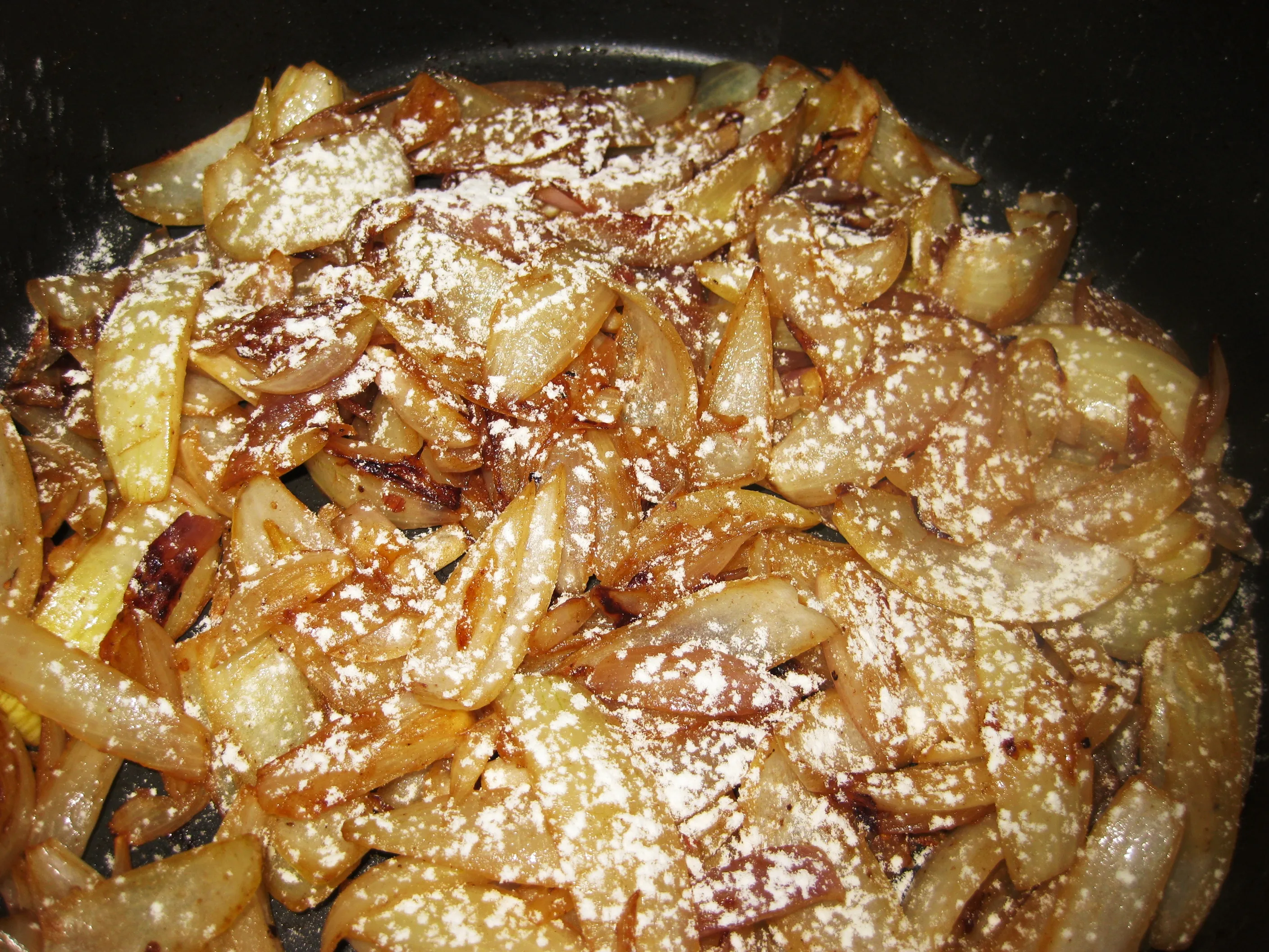 Zwiebeln und Schalotten werden in einem Topf angebraten und mit Mehl bestäubt.