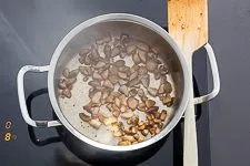 Zwiebeln und Steinpilze werden in einem Topf angedünstet
