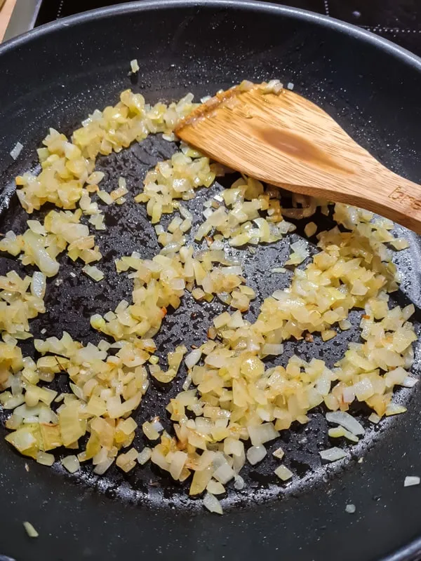 Zwiebelwürfel in einer Pfanne goldbraun anbraten – erster Schritt zum einfachen Labskaus