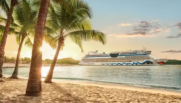 AIDAluna in der Karibik mit Palmen am Strand