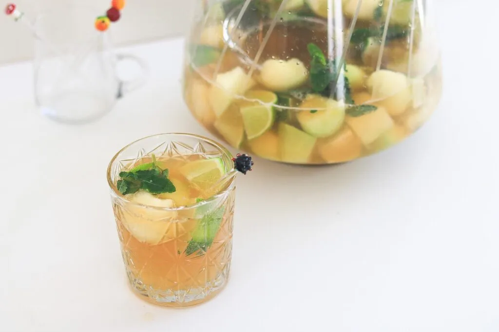 Alkoholfreie Caipirinha Bowle mit Honigmelonenkugeln und Limettenscheiben