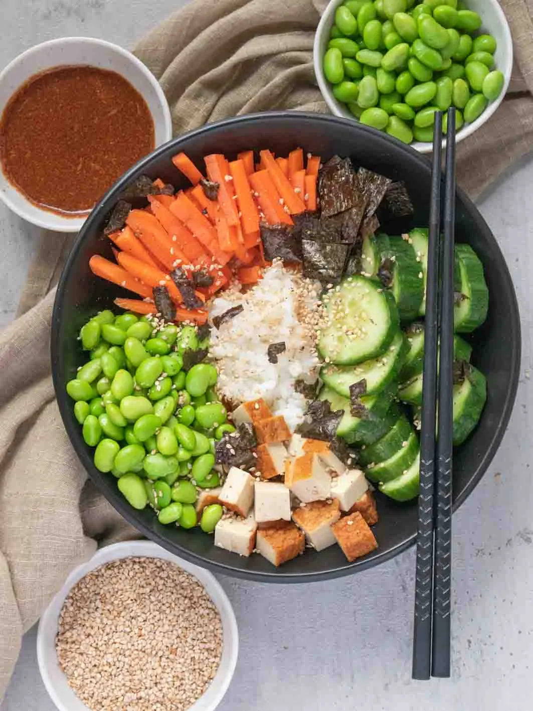An angerichtete Sushi Bowl mit Reis, Tofu, Gemüse und Sauce