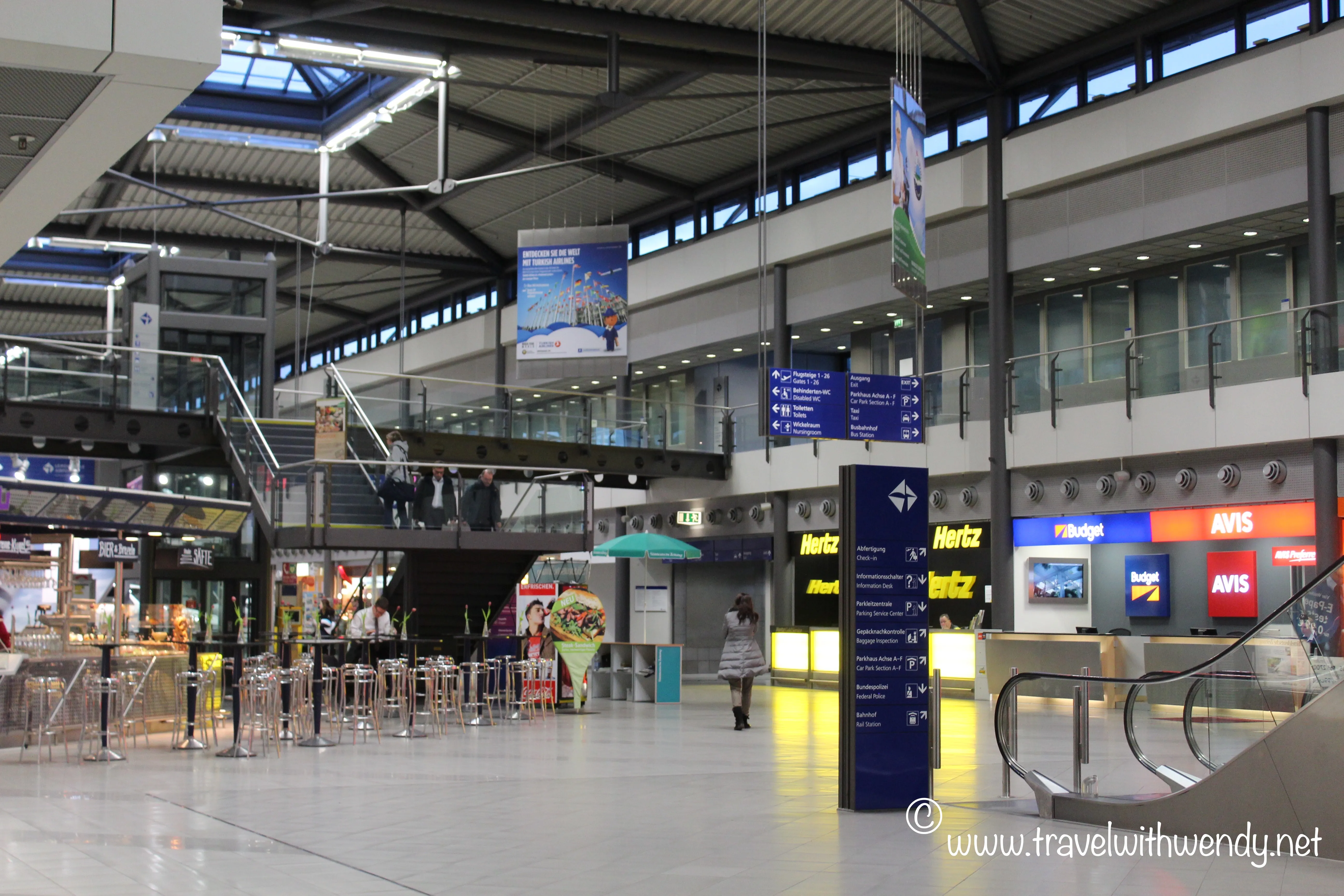 Ankunftsbereich eines Flughafens mit einem Eurowings-Flugzeug im Hintergrund