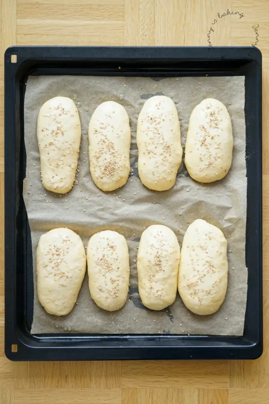 Aus dem Ofen kommende, goldbraune Hot Dog Brötchen, die ihre perfekte Form und Weichheit zeigen