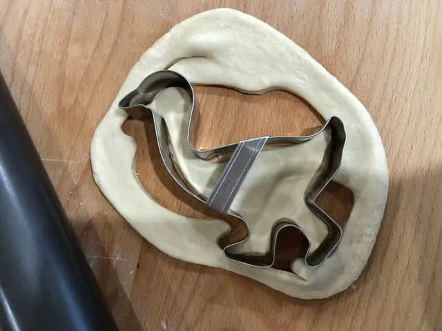 Ausgestochene Gänseformen aus Hefeteig auf einem Backblech