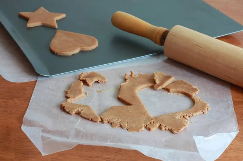 Ausgestochene Linzer Plätzchen und deren Oberteile mit Loch auf einem Backblech vor dem Backen