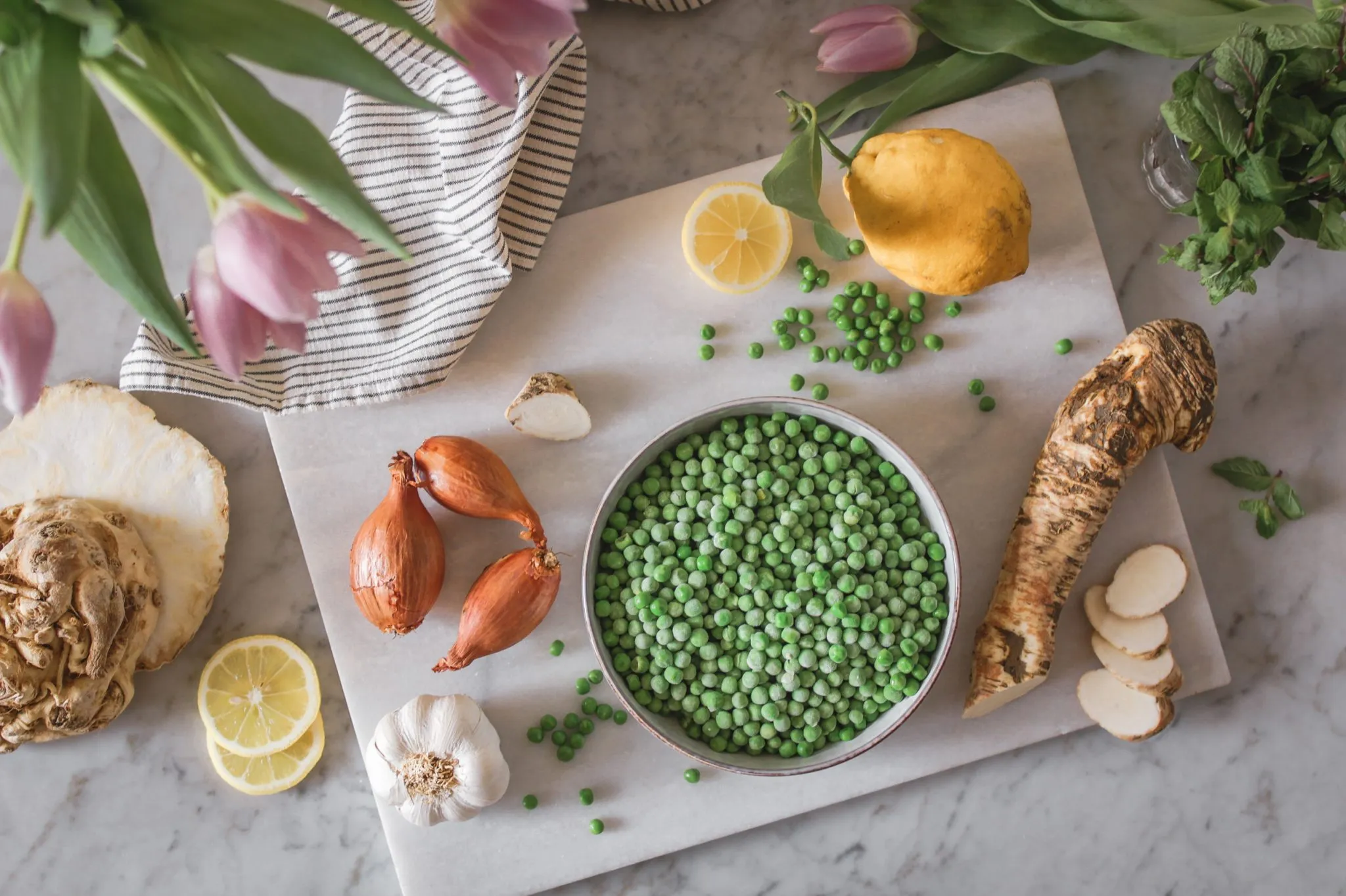 Ausgewählte Zutaten für die Erbsen-Kokossuppe, appetitlich auf einem Holzbrett angerichtet