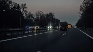 Autobahn bei Dunkelheit, Scheinwerfer von entgegenkommenden Fahrzeugen