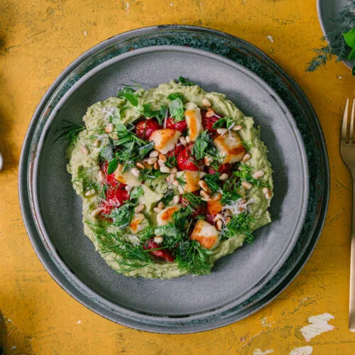 Basilikum-Polenta mit Halloumi und Ofentomaten servierfertig auf einem Teller